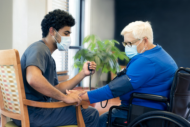 CNA checks woman’s blood pressure 